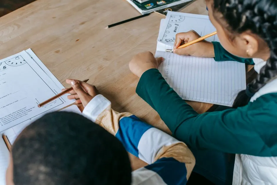Printed worksheet on a classroom desk beside sharpened pencils and a mini whiteboard